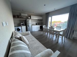 a living room with a couch and a table with chairs at Quequen Casa las Olas frente al mar 4 pax in Quequén