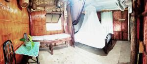 a bedroom with a bed and a table in a room at Nature's Cabin in Donsol +15 photos