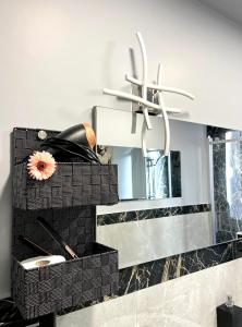 a bathroom with a mirror and a chandelier at Le Crudi Home Genova Pegli in Genova