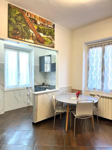 a kitchen and dining room with a table and chairs at Le Crudi Home Genova Pegli in Genova