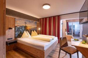 Postel nebo postele na pokoji v ubytování Das Sonnleiten Ski- und Motorradhotel Bruck im Zillertal
