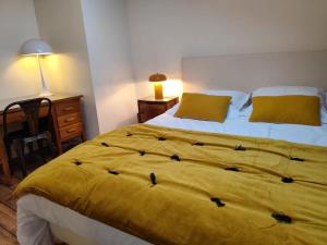 a bedroom with a bed with a yellow blanket at le marais in Romans-sur-Isère