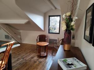 a living room with a table and a vase of flowers at le marais in Romans-sur-Isère