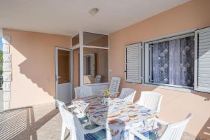 ein Esszimmer mit einem Tisch und weißen Stühlen in der Unterkunft Apartments Daniela in Zavalatica