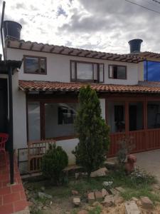 ein weißes Haus mit einem roten Dach in der Unterkunft Family Apartment Alojamiento Sachica Villa de Leyva in Sáchica