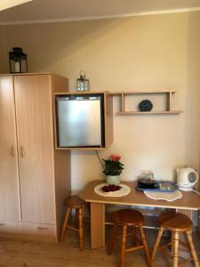 a kitchen with a table with stools and a tv at Pensjonat Klaudia in Ostrowo