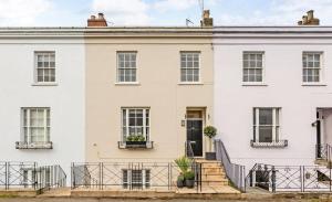 a white house with black railing at Beautiful Modern Central Flat in Cheltenham