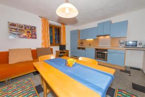 kuchnia i salon ze stołem i kanapą w obiekcie Ferienwohnung Franck w mieście Kleinarl +10 zdjęć