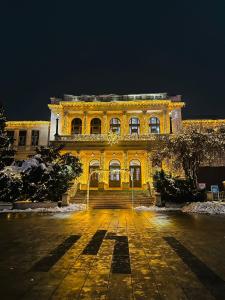 ein großes gelbes Gebäude mit einer Treppe davor in der Unterkunft The Riverside Harmony Sarajevo - Parking available - Walk everywhere in Sarajevo