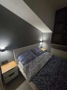 a bedroom with a bed with a black and white blanket at Centrum Jacuzzi prywatny parking klimatyzacja 5 in Radom
