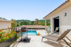 eine Terrasse mit Stühlen und einem Swimmingpool in der Unterkunft Les Villas de la Résidence U Veniqui in Favone