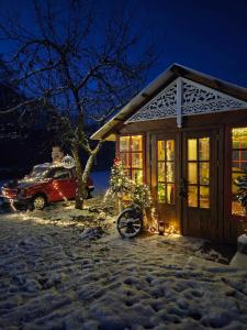 ein Haus mit einem Auto, das nachts im Schnee geparkt ist in der Unterkunft STACJA RUDA in Złota Wieś