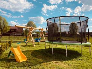 a playground with a trampoline in the grass at Izby na Równi in Witów