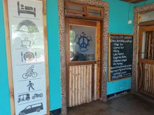a door to a restaurant with a sign and a chalkboard at Peace and Love Garden in Mto wa Mbu