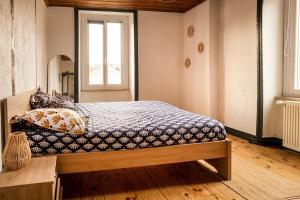 a bedroom with a bed with a bench and a window at Bienvenue chez vous ! in LʼEstrade