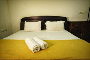 a bed with two towels sitting on top of it at starhive homestay in Kalpetta