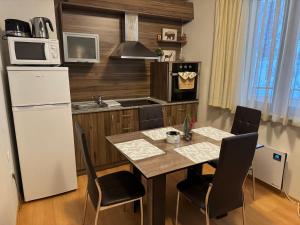 a kitchen with a table with chairs and a refrigerator at Forest Apartment/ Villa Park in Borovets