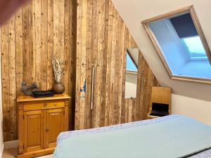a bedroom with a bed and a wooden wall at Schaapskooi 20 in Dwingeloo