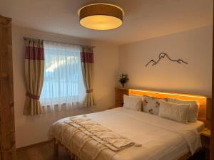 a bedroom with a large bed with a large window at Nedererhof - Ferienwohnung Hoamat in Schmirn