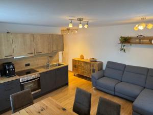 a living room with a couch and a kitchen at Nedererhof - Ferienwohnung Hoamat in Schmirn
