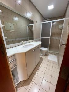 トーレスにあるFlat 100m da praia, vista mar com garagem, central e completo!の洗面台、トイレ、鏡のあるバスルーム