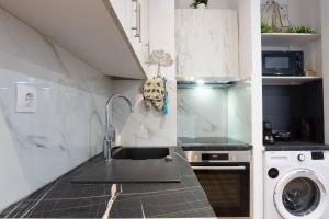 una cocina con fregadero y lavadora en Paradise+ With Jacuzzi In the heart of Athens!, en Atenas