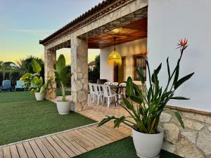 a patio with a table and chairs and plants at Can Pines in Paradas