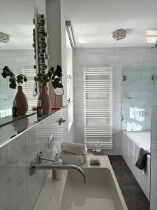 a bathroom with a bath tub and a sink at Haus ROSENSTEIN in Sassnitz +13 photos