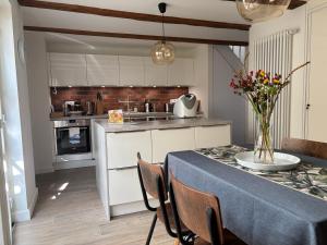 a kitchen with a table with a vase of flowers on it at Haus ROSENSTEIN in Sassnitz