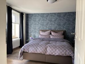 a bedroom with a bed with a blue wall at Haus ROSENSTEIN in Sassnitz