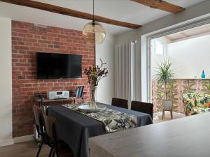 a dining room with a table and a brick wall at Haus ROSENSTEIN in Sassnitz