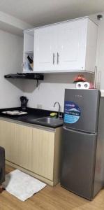 a small kitchen with a sink and a refrigerator at Amhiel's Condo Rental Services in Minglanilla