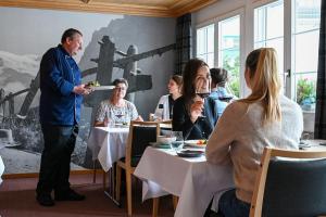 a man holding a plate of food in a restaurant at Hotel St. Josefshaus Engelberg in Engelberg +17 photos