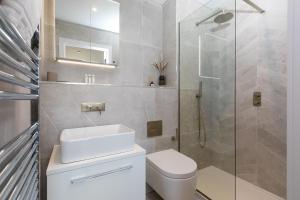 a bathroom with a toilet and a glass shower at 14 An Garth in Hayle +17 photos