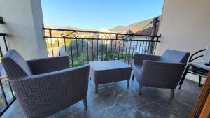 a patio with chairs and a table and a balcony at NY Apartment, two bedrooms in Tivat