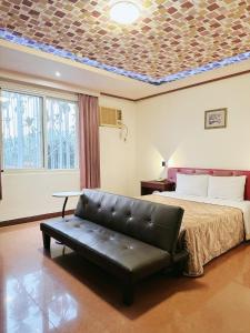 a living room with a bed and a couch in it at Hua Du Motel in Jiji