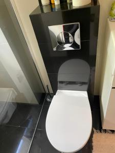 a white toilet in a bathroom with a black wall at Apartament Kołobrzeg in Kołobrzeg +13 photos