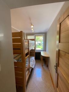 a room with bunk beds and a desk and a window at Apartament Kołobrzeg in Kołobrzeg
