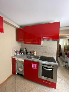 a kitchen with red cabinets and a sink at Apartament Kołobrzeg in Kołobrzeg