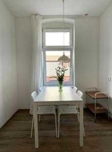 a white table and chairs in a room with a window at Apartment Katowice Center - Słowackiego in Katowice