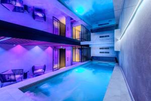 an indoor swimming pool in a building with purple lighting at Hôtel Anne de Bretagne in Saint Malo