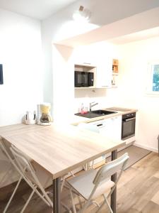 a kitchen with a wooden table and chairs at maison proche plage du pouliguen baie de la baule in Le Pouliguen