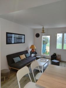 a living room with a couch and a table at maison proche plage du pouliguen baie de la baule in Le Pouliguen