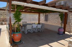 a patio with a table and chairs under a pergola at Villa Blu Majestic beach villa in Halki