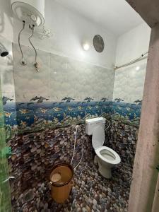 a bathroom with a toilet and a fish mural on the wall at Ilford Castle Home Stay Pondicherry in Puducherry +13 photos