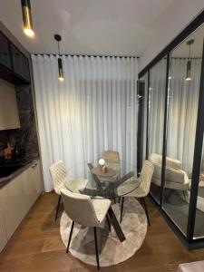 a living room with a glass table and chairs at FIRST CLASS Apartments Zlatibor 2 in Zlatibor