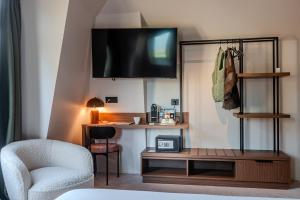 un salon avec une télévision et une chaise dans l'établissement Hôtel Anne de Bretagne, à Saint-Malo