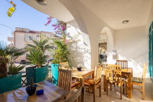 a dining room with tables and chairs and plants at Apartments POLARIS in Baška Voda