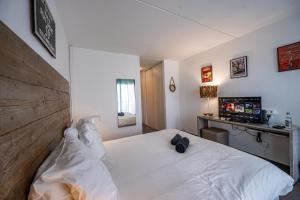 a bedroom with a white bed and a desk at Mango Chik Meublé Classé 2 étoiles ! in Saint-François +10 photos
