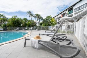a patio with chairs and a swimming pool at Mango Chik Meublé Classé 2 étoiles ! in Saint-François